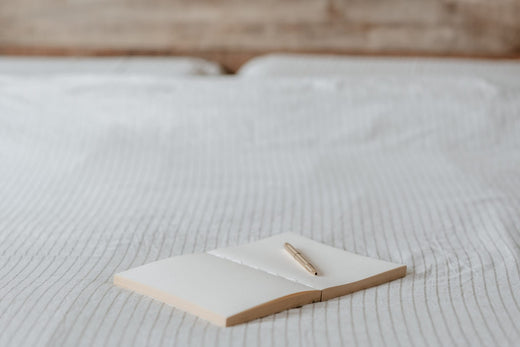 a book and a pen in bed