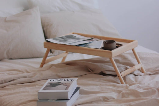 a bed with Linenly bamboo beddings and a breakfast tray