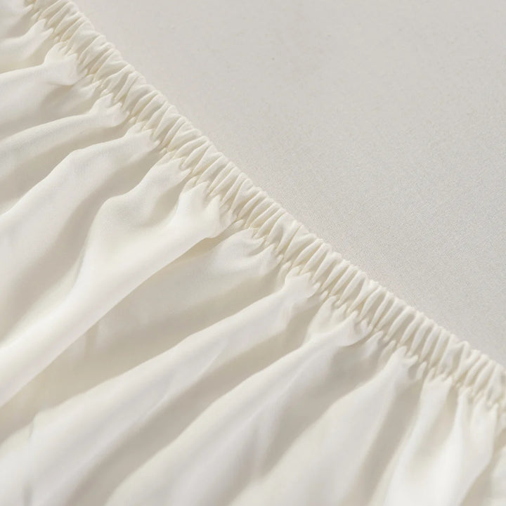 Close-up view of a neatly gathered elastic seam on Linenly's Ivory Bamboo Fitted Sheet, demonstrating refined textile workmanship in eco-friendly choice fitted sheets.