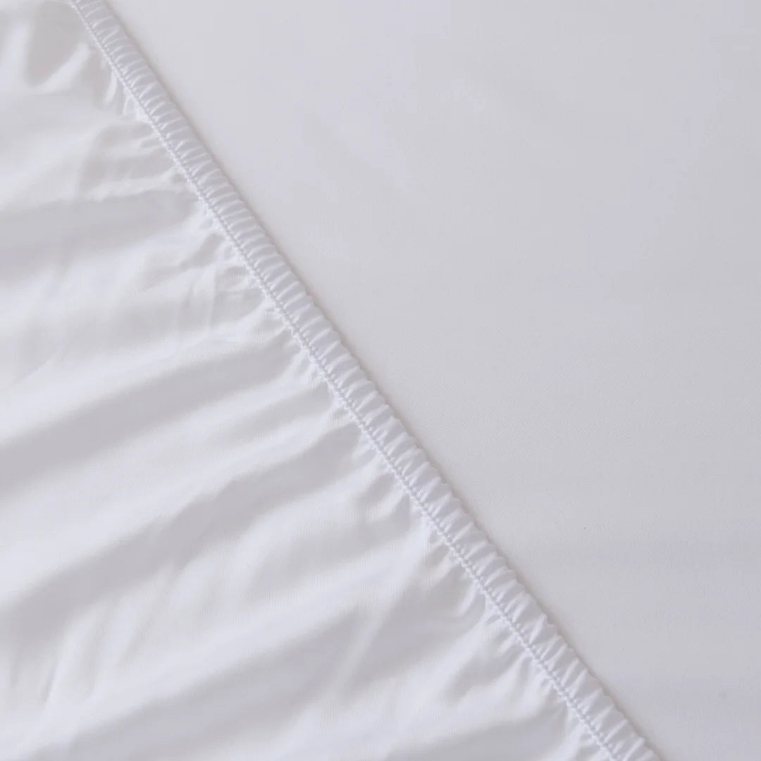 Close-up of a Linenly Bamboo Fitted Sheet - White with deep sides, crisp white fabric featuring a detailed view of its smooth texture and clean, finished edge.