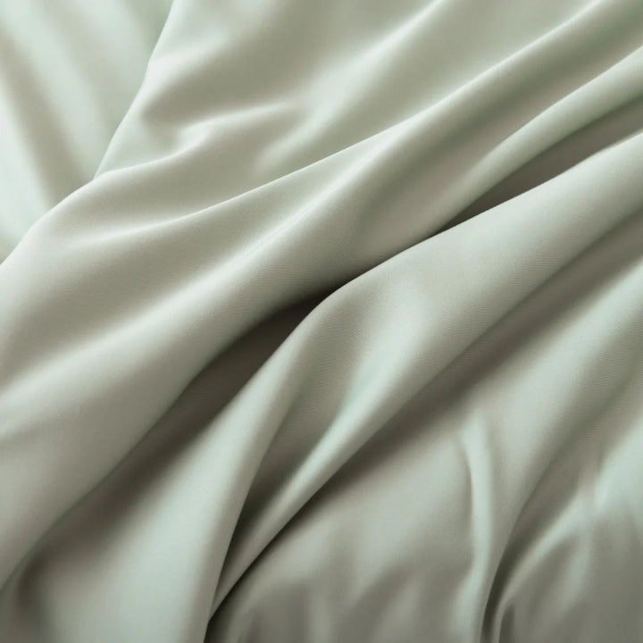 Elegant Linenly bamboo pillowcase set in a luxurious sage green, draped softly with gentle folds and a smooth, lustrous surface.