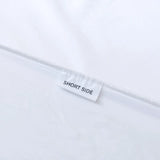 A white fabric label stitched onto the Linenly Luxe Cotton Sateen Sheet Set - White reads "SHORT SIDE" in black, indicating sheet orientation against a plain white background.