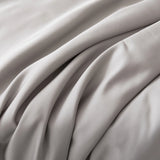 Close-up of the Bamboo Pillowcase Set - Silver by Linenly, showcasing smooth, light gray organic bamboo fabric with soft folds and gentle shadows that highlight its luxurious texture and elegant movement.